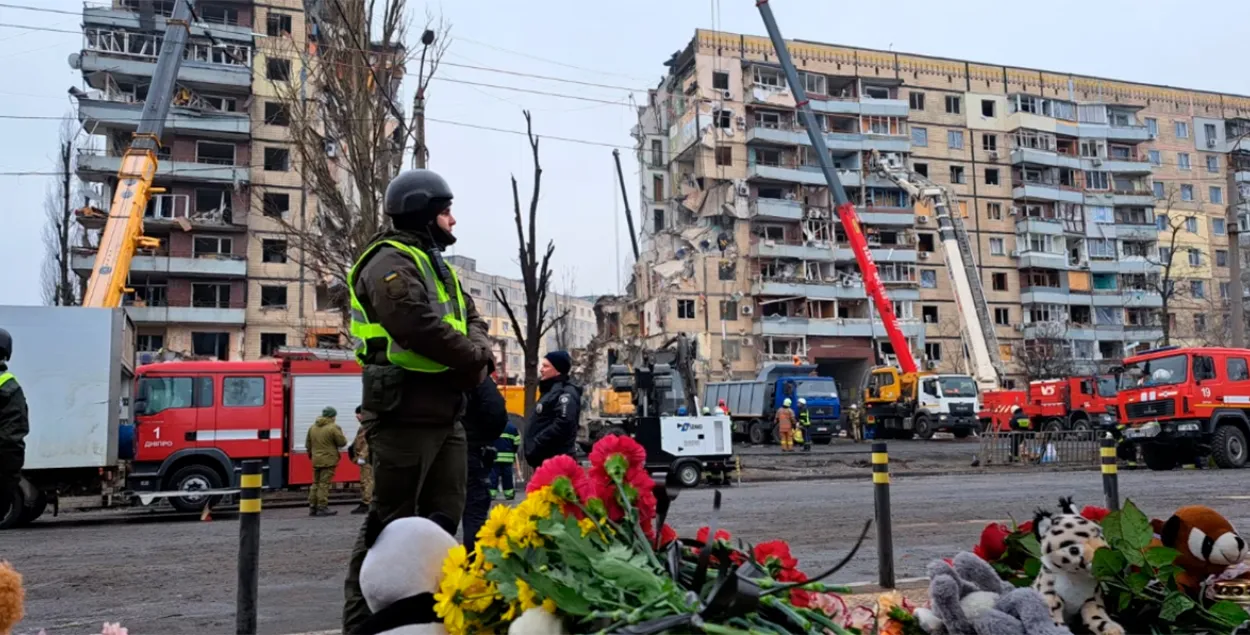 Людзі нясуць кветкі, знічкі і цацкі да разбуранага будынка ў Дняпры / RFE/RL
