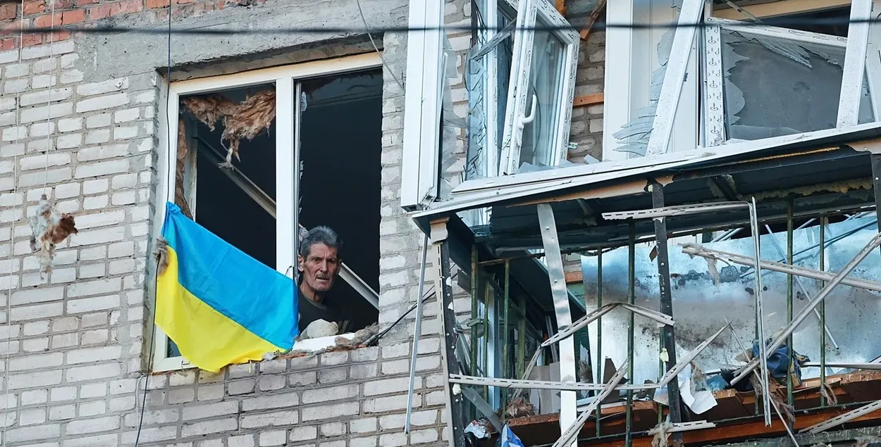 Украінец са сцягам у акне разбуранага дома

