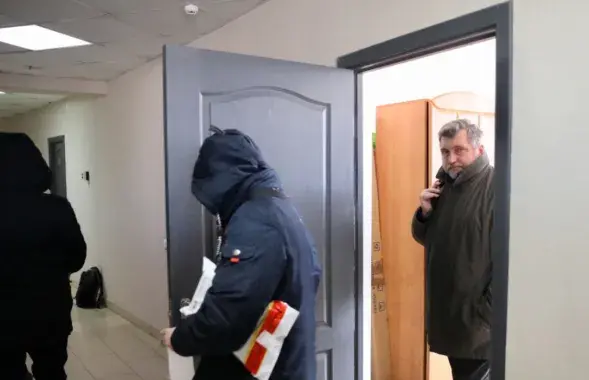 Сілавікі і старшыня БАЖ Андрэй Бастунец пакідаюць офіс арганізацыі пасля ператрусу / svaboda.org
