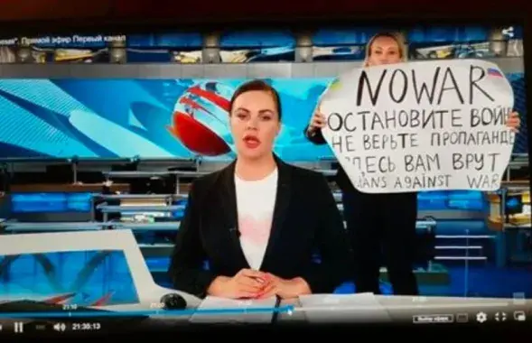 The woman with an No War! poster&nbsp;/ screenshot from video